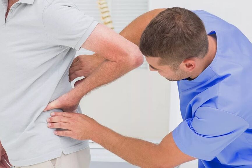 Pacient s bolestí zad při diagnostickém vyšetření lékařem